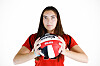Olivia Perez in a red volleyball jersey holds a volleyball against a white background.
